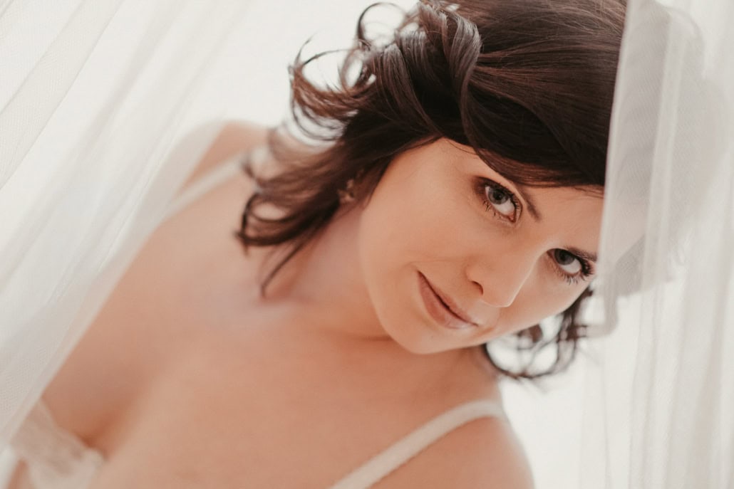 Junge Frau mit braunen Haaren und natürlichem Make-up, lächelnd.