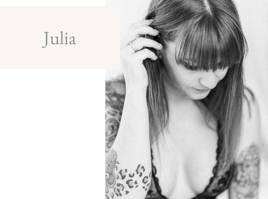 Porträt einer Frau mit Tattoos, dunklem Haar und nachdenklichem Ausdruck, ideal für Boudoir-Fotograf.