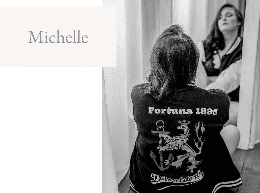 Porträt einer Frau bei einem Boudoir-Shooting, im Hintergrund eine andere Frau sitzend, schwarz-weiß. - Dein Boudoir Entspanntes Boudoir-Fotoshooting mit zwei Frauen, eine sitzt im Hintergrund, die andere steht mit Rü.