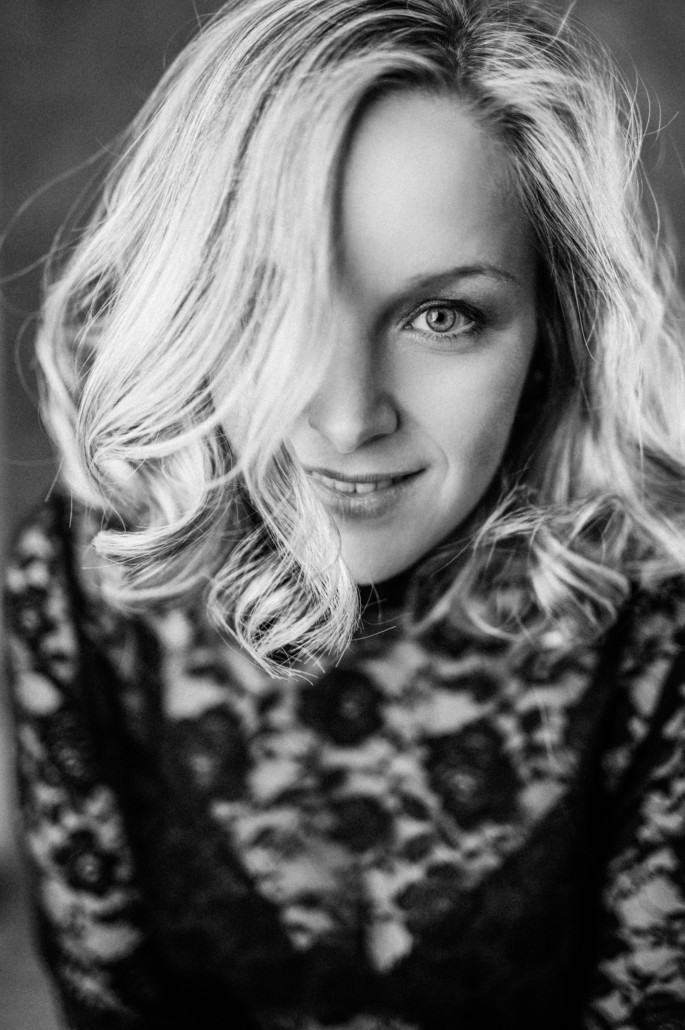 Porträt einer Frau mit lockigem Haar und verführerischer Ausstrahlung, Erotik Fotografie vom Dein Boudoir Studio.